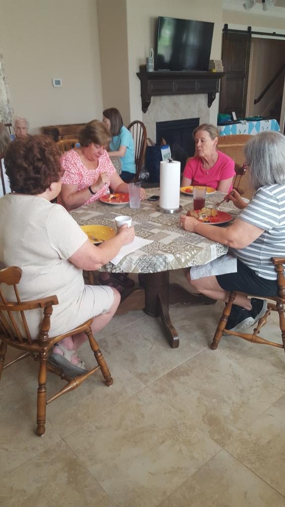 Four women enjoying a meal together at the round dining table in the sitting area