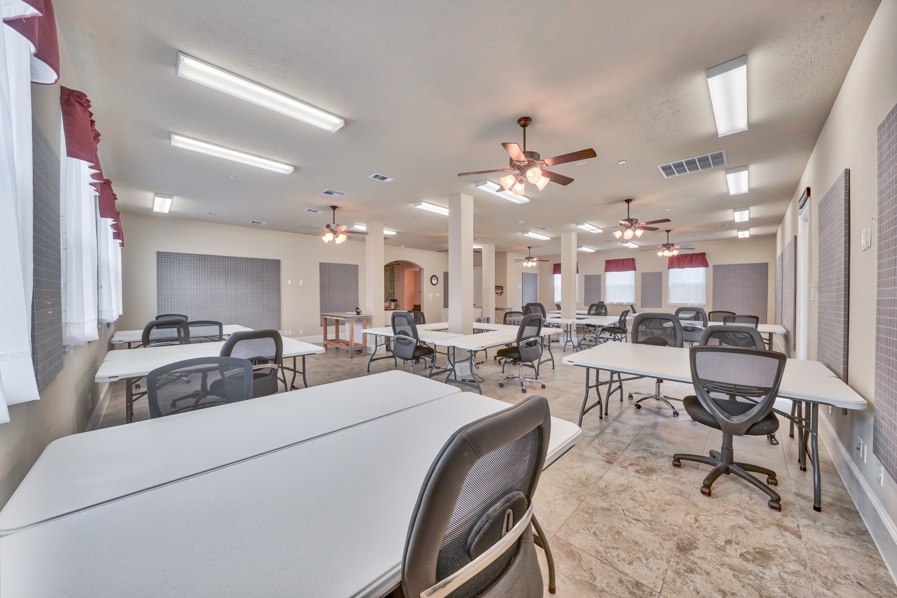 Large 1,600 sq ft workroom with tables, chairs, ceiling fans, and design walls